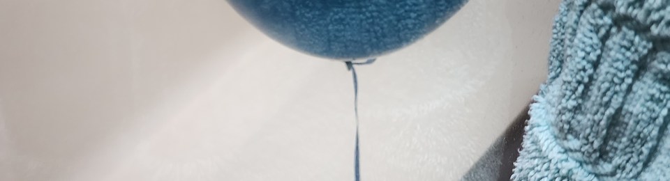 a blue balloon sits in a bathtub